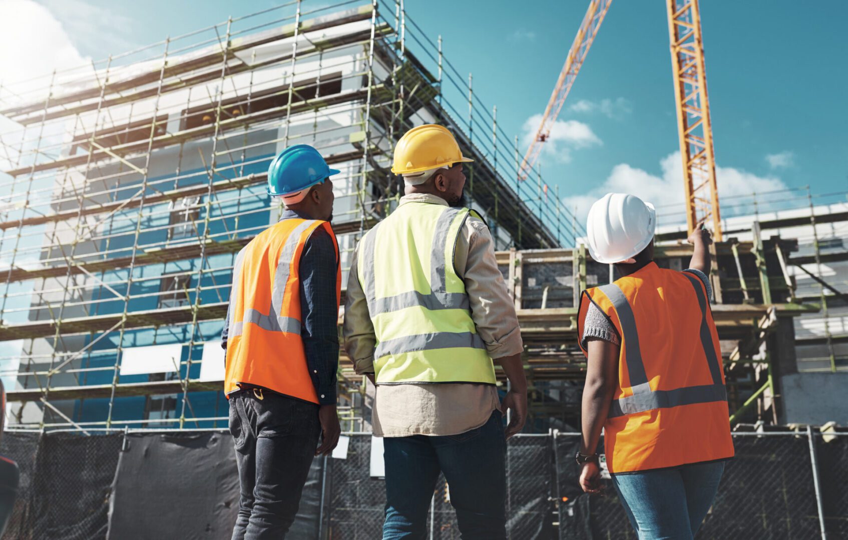 Delivering quality construction for a quality lifestyle Construction workers observing building site progress.